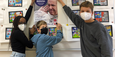 Lisa, Michael und Matthias beim Plakataufhängen in der Klosterschule Neusiedl.