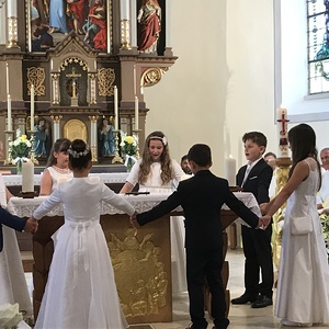 Die Erstkommunionskinder tanzen zu einem selbstgesungenen Lied um den Altar
