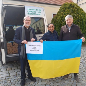Bei der Übergabe der Kartons mit dem Bus. Propstpfarrer P. Lorenz Voith, Pastoralassistent Fred und Fahrer Stephan