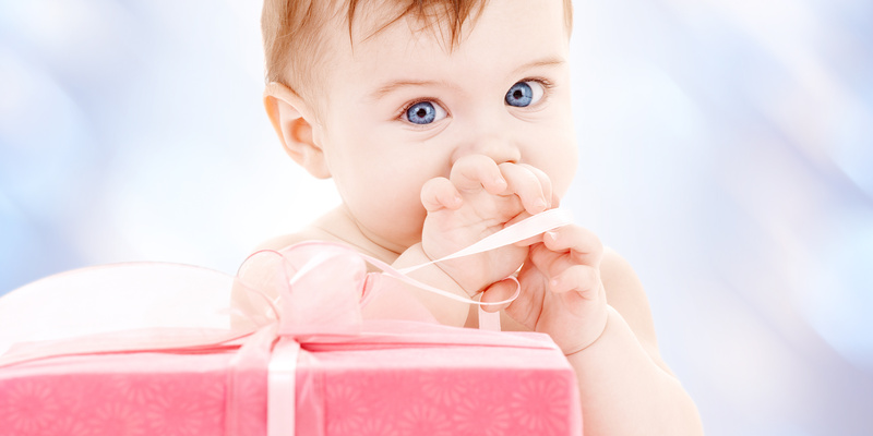 Baby staunt über ein noch verpacktes Geschenk