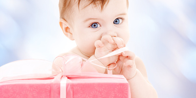 Baby staunt über ein noch verpacktes Geschenk