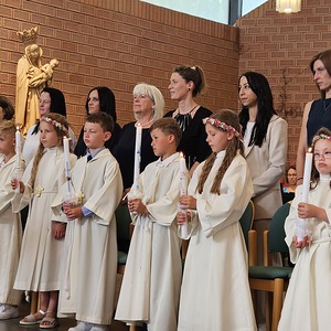 Erstkommunionkinder mit Taufpaten und Taufkerzen