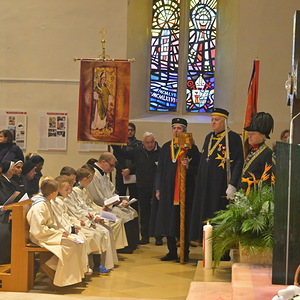 Ministrant:innen und Ordensschwestern sitzen in den ersten Reihen.